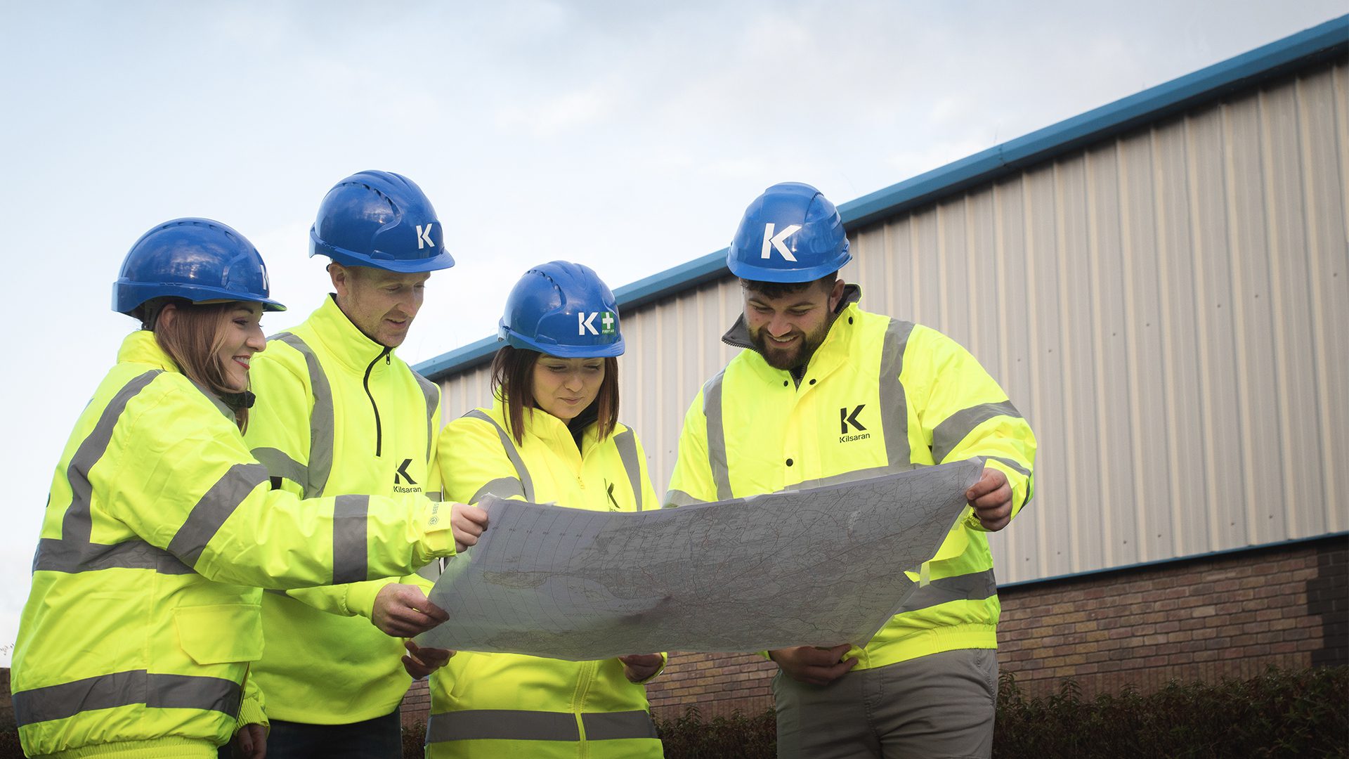 gender pay gap reporting image, Male and Female workers holding construction plan
